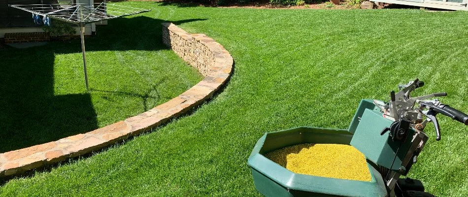 Lawn, stone retaining wall, and a granular spreader in Hemby Bridge, NC.